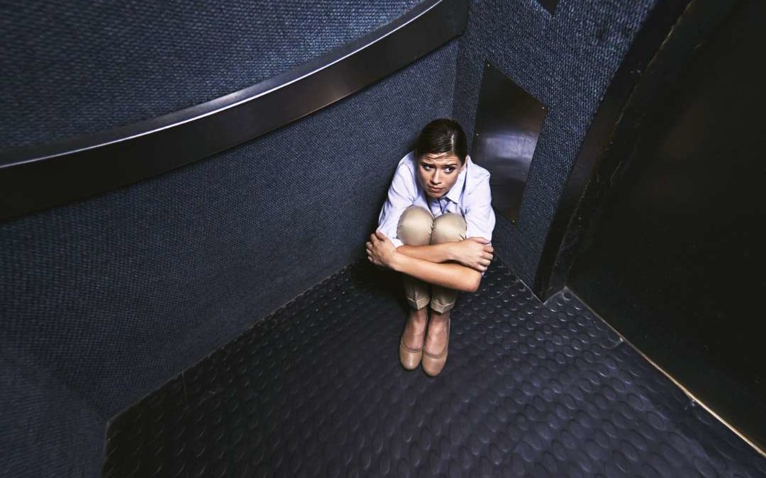Chica atrapada en un ascensor sentada en el suelo